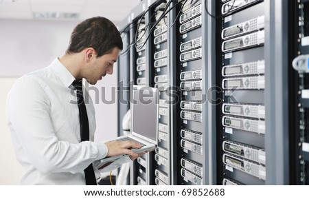 young it  engeneer business man with thin modern aluminium laptop in network server room