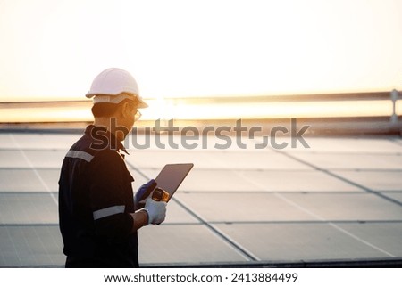 Young engineer checking the cleanliness of solar panels. Concept: renewable energy, clean technology, electric power.