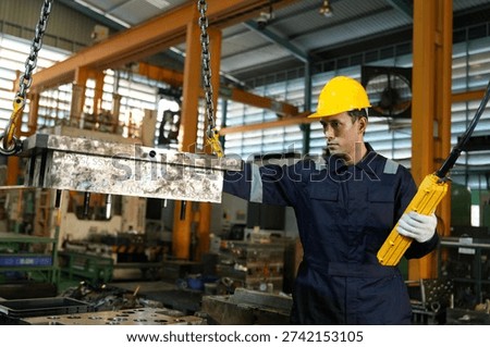 A young engineer and foreman remotely inspects automotive parts and controls production to ensure quality in an automotive factory.