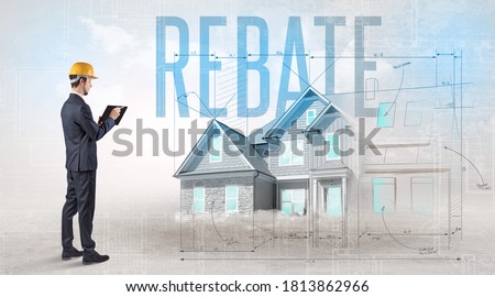 Young engineer holding blueprint with REBATE inscription, house planning concept