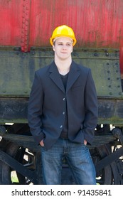 young engineer standing in front of old train