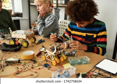 Young engineer using soldering iron to join chips and wires. Robotics and software engineering for elementary students. Inventions and creativity for kids. Tinkering, educational activities concept.
