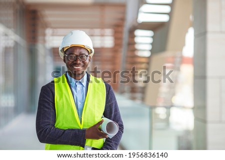 Young engineer working on a construction worksite. Young businessman construction site engineer,close up. Professional engineer in safety equipment at construction site