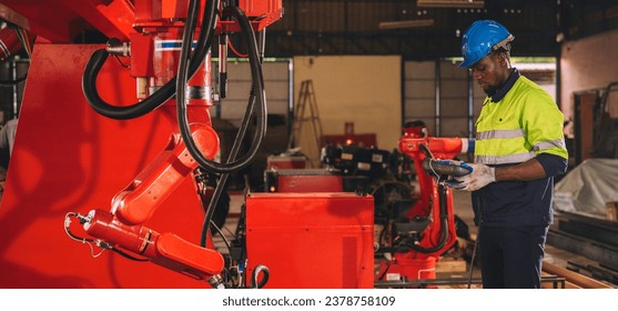 Young engineer works diligently in advanced robot welding factory in modern technology world. - Powered by Shutterstock