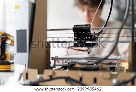 Young engineering student using a 3D printer in the lab