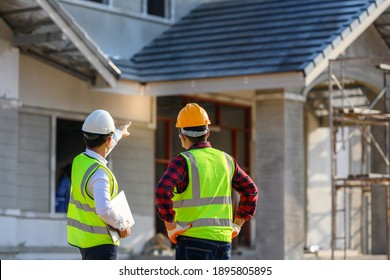 Young engineers and architects oversee the construction of houses on the construction site. - Shutterstock ID 1895805895