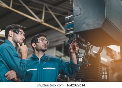 Young Engineers Are Doing Practical On The Job Training On How To Use A Controller For A Factory By Computer.