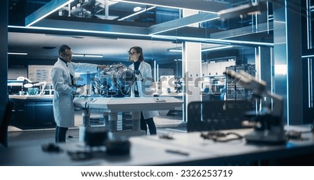 Young Engineers Using Tablet and Laptop Computers, Collaborate on a New Type of a Electric Turbine Engine, Using Software for Testing Equipment in Scientific Technology Laboratory