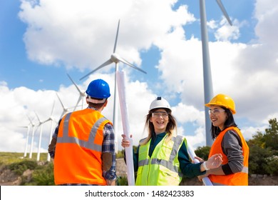 Young Engineers And Workers Having A Meeting At Wind Farm