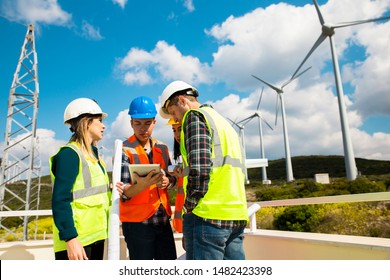 Young Engineers And Workers Having A Meeting At Wind Farm