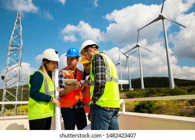 Young Engineers And Workers Having A Meeting At Wind Farm