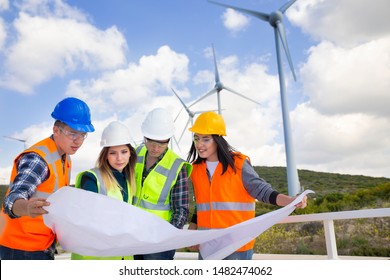 Young Engineers And Workers Having A Meeting At Wind Farm