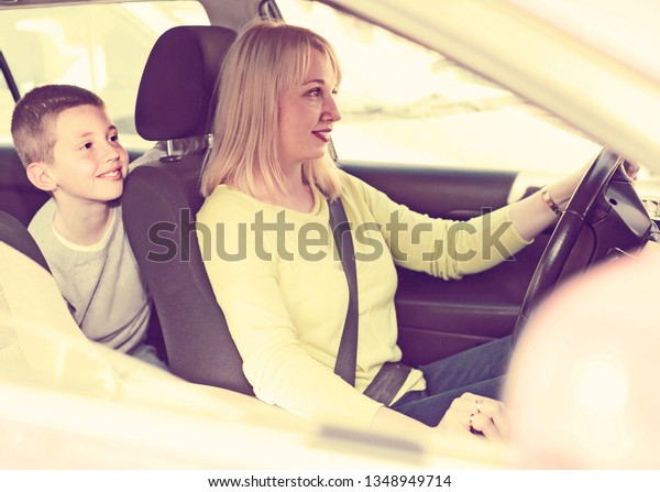 Young english mother and son taking car ride during\
sightseeing tour