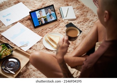 Young Entrepreneur Eating Breakfast And Attending Online Meeting With Colleagues