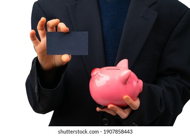 Young Entrepreneur Holding Business Card Next To Piggy Bank. Financial Education For Kids.