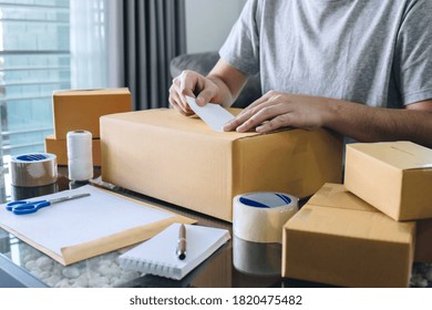 Young Entrepreneur SME Man Receive Order Client And Working With Packaging Sort Box Delivery Online Market On Purchase Order And Preparing Package Product, Small Business Parcel For Shipment.