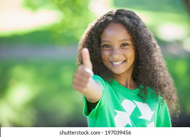 Young environmental activist smiling at the camera showing thumbs up on a sunny day - Powered by Shutterstock