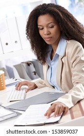 Young Ethnic Businesswoman Sitting At Desk, Working On Computer.