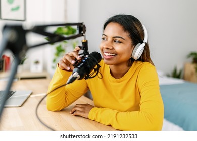 Young ethnic woman recording radio podcast - Millennial female content creator working from home studio - Creative people and freelancer lifestyle concept - Powered by Shutterstock