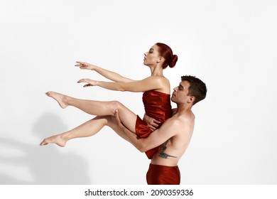 Young European Dance Couple Dancing Classical Ballet Dance. Choreography Concept. Man With Tattoo Holding Woman In Arms. Woman Wearing Red Nightie. People Isolated On White Background In Studio