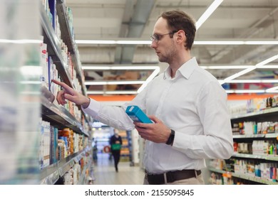 Young European Man Buying Shampoo In Shopping Mall