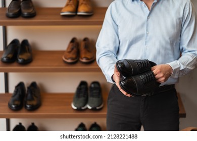 Young European Man With Dark Hair Brings Wardrobe Order Puts Everything In Its Place. Closet Organized. Man Chooses Clothes. Capsule Wardrobe For Men.