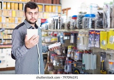Young european man deciding on best DIY details in houseware store - Shutterstock ID 797096191