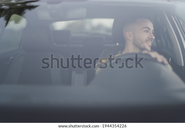 A young European man\
driving his car