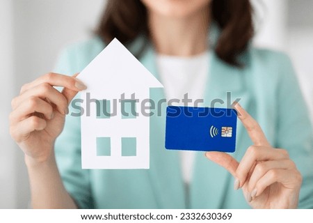 Young european woman realtor manager in suit shows house and credit card in office, cropped. Businesswoman and business, real estate purchase, mortgage, loan and banking, new house