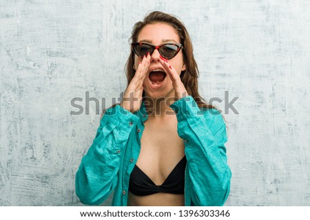 Young european woman wearing bikini shouting excited to front.