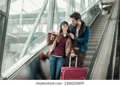 Young excited couple on the escalator while waiting for the train in a train station - Powered by Shutterstock