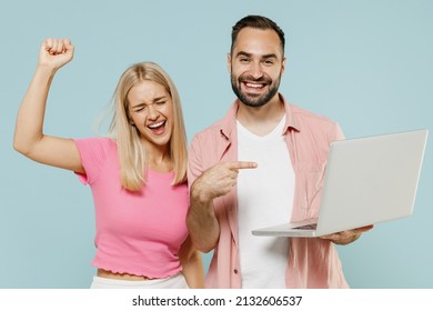 Young Excited Couple Two Friends Family Man Woman In Casual Clothes Hold Use Work Point On Laptop Pc Computer Do Winner Gesture Together Isolated On Pastel Plain Light Blue Background Studio Portrait