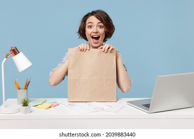 Young Excited Employee Business Woman Wear Shirt Sit Work At White Office Desk With Pc Laptop Craft Blank Paper Takeaway Bag Product Delivery Courier Service Isolated On Pastel Blue Background Studio