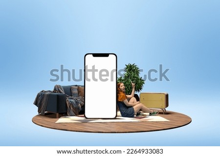 Young excited girl sitting near giant 3D model of phone screen with empty space for text, ad over blue background with home interior. Online shopping, delivery. Mockup for design, logo.