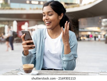 Young Excited Indian Woman Using Mobile Phone Shopping Online With Sale Sitting In Cafe. Happy Hipster Female Playing Mobile Game. Asian Student Reading Exam Results 