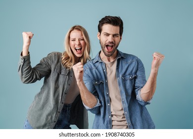 Young Excited Man And Woman Screaming And Making Winner Gesture Isolated Over Blue Background