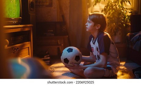 Young Excited Sports Fan Watches A Soccer Match On TV At Home. Boy Supporting His Favorite Football Team, Feeling Proud When Players Score A Goal. Nostalgic And Retro Childhood Concept.