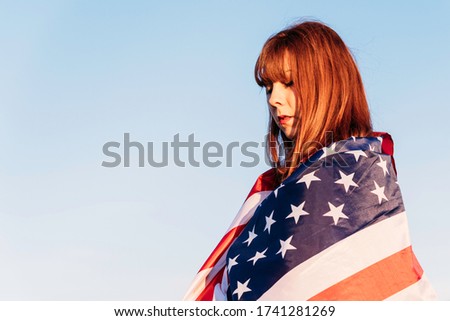 Young excited woman with the United States flag enjoying in nature. July 4 independence day of the united states