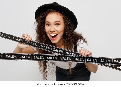 Young Excited Woman Wear T-shirt Hat Hold In Hand Red Paper Package Bags After Shopping Touch Tape With Sale Written Text Isolated On Plain Solid White Background. Black Friday Sale Buy Day Concept