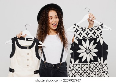 Young Excited Woman Wear T-shirt Hat Hold In Hand Red Paper Package Bags After Shopping Choose Dresses Apparel Isolated On Plain Solid White Color Background Studio. Black Friday Sale Buy Day Concept