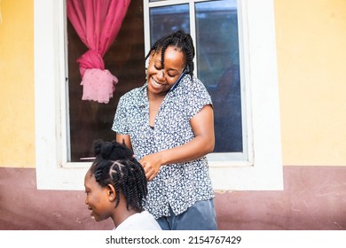 Young Exciting African Female Hair Dresser Making And Receiving Phone Call