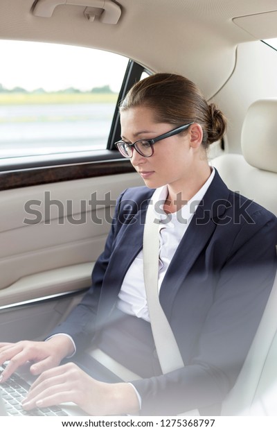 Young executive using\
laptop in car