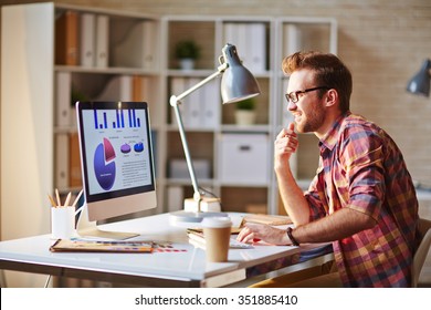 Young Executive Working With Graphs On His Computer