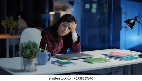 Young Exhausted Caucasian Woman Working Long Hours In Office. Angry Female Employee Closing Laptop Finishing Work And Frustrating.