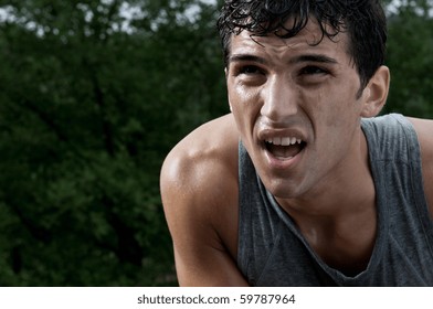 Young exhausted latin man looking at the rest of path during a break of his outdoor jogging training - Powered by Shutterstock