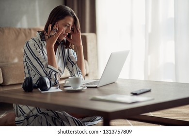 young exhausted and worried woman working at home with a laptop - Shutterstock ID 1313757809