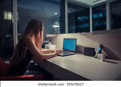 Young exhausted,depressed,concentrated woman sitting in her room or office with french windows  in the dark at the lamp.Studies late at night.Staying up late. Overworking.  - Shutterstock ID 391670617