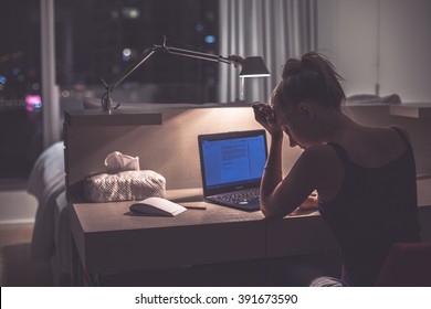 Young exhausted,depressed,concentrated woman sitting in her room or office with french windows in the dark.Studies late at night.Staying up late. Overworking.Feeling under pressure and headache - Shutterstock ID 391673590