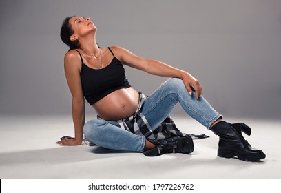 Young Expectant Mother In Casual Stylish Hip Hop Clothes
Full-body Portrait Of Pregnant Woman.
Stylish Pregnant Mom Posing At Studio.
Pretty Expectant Woman With Naked Belly Wear Jeans And Black Top