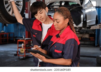 Young expertBlack female inspects repair checklist with automotive mechanic worker partner, quality suspension technician team at fix garage. Vehicle maintenance service works industry occupation. - Powered by Shutterstock